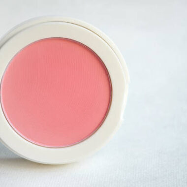 Pink blush powder makeup on white clothing background, cosmetics concept