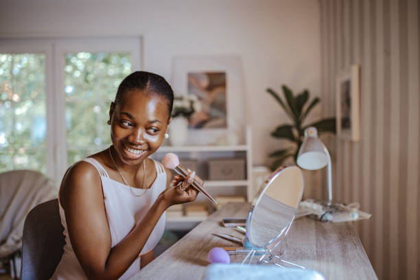 Young black woman perfecting her makeup for prom